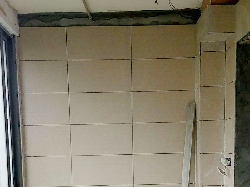 衛(wèi)生間瓷磚鋪貼：基層處理：將凸出墻面的混凝土剔平，對于基體為混凝土表面很光滑的要鑿毛，或用可摻界劑膠的水泥水細砂漿做小拉毛墻，也可以刷界面劑、并澆水濕潤基層。浸磚：面磚鑲貼前，應(yīng)挑選顏色、規(guī)格一致的磚；浸泡磚時，將面磚清掃干凈，放入凈水中浸泡2小時上，取出待表面晾干或擦干凈后方可使用。粘貼面磚：粘貼應(yīng)自下而上進行。抹8㎜厚1：0.1：2.5水泥石灰膏砂漿結(jié)合層，要刮平，隨抹隨自上而下粘貼面磚，要求砂漿飽滿，虧灰時，取下重貼，并隨時用靠尺檢查整度，同時保證縫隙寬度一致。