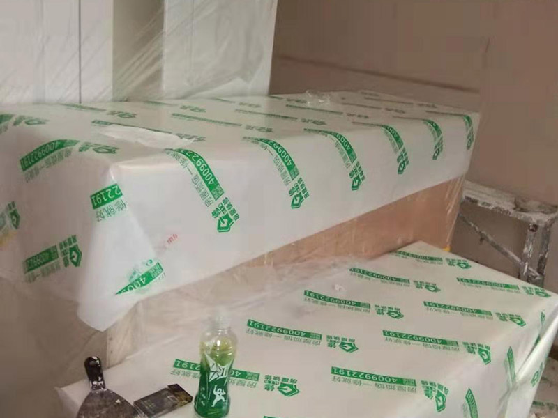 全屋家具成品保護(hù)：滿鋪成品瓦楞紙板，再用干凈彩條布滿鋪在普通石膏板上，在彩條布交接處及轉(zhuǎn)角處用膠帶固定，也可選用木芯板或三夾板。材料選用視上人、車情況而定。 所有成品飾面板在安裝好后必須用PE保護(hù)膜覆蓋包起來(lái)，所有成品飾面板的陽(yáng)角位必須用硬質(zhì)紙護(hù)角或泡沫棉進(jìn)行保護(hù)性包裝，防止交被其他施工人員碰撞。 1、入戶門扇用公司統(tǒng)一的門貼進(jìn)行全面包裹保護(hù)，用透明膠帶將保護(hù)膜粘貼牢固平整。 2、用標(biāo)準(zhǔn)保護(hù)膜將門框三面保護(hù)完整并固定牢固。 3、工程完工后拆除保護(hù)膜時(shí)如果有粘貼時(shí)的膠痕，應(yīng)用酒精或?qū)Ｓ玫那逦蹌┣宄z痕。